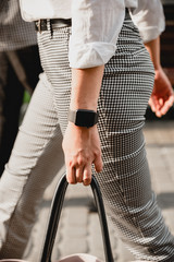 Charming girl with long brown hair and a man with a beard kissing on the background of the morning city. Newlyweds on their wedding day