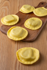 Top view of mushroom ravioli on kitchen table and wooden table, vertical