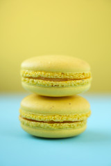 Colorful macarons on yellow and blue background
