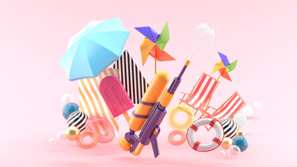 Squirt gun surrounded by umbrellas, rubber rings, beach chairs and turbines surrounded by colorful balls on a pink background.-3d rendering..