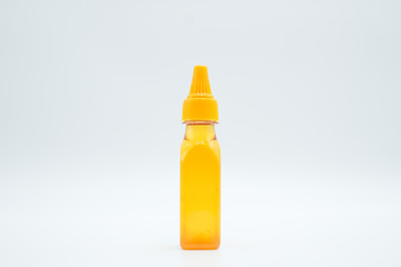 Honey in a bottle shot in a white isolated background