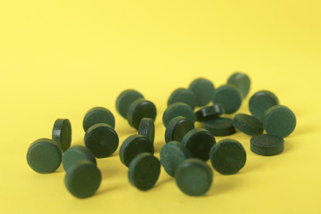 pastillas verdes desordenadas en fondo amarillo
