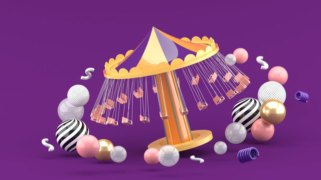 fairground rides surrounds many colorful balls on a purple background.-3d rendering..