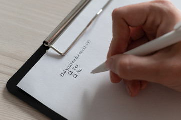Unrecognizable woman puts a daw in the questionnaire. A close-up of a female hand answering about a...