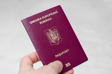 Close up view of a Romanian passport on a white background . Documents required to travel to countries around the world .