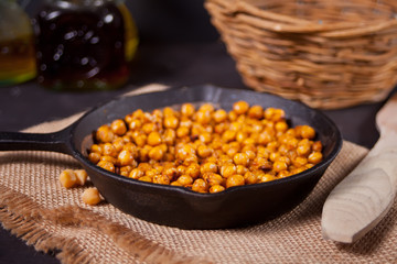 Spicy roasted chickpeas in a black metal pan. Healthy and vegetarian food.