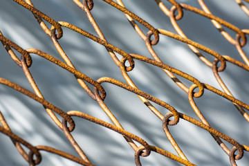 Background from a yellow metal mesh. The grid has rusty large cells.