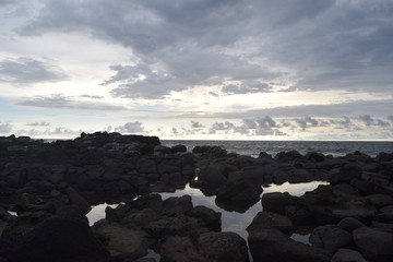 Paisaje tranquilo reflejo del cielo en el agua atrapada entre las grandes rocas de la costa
