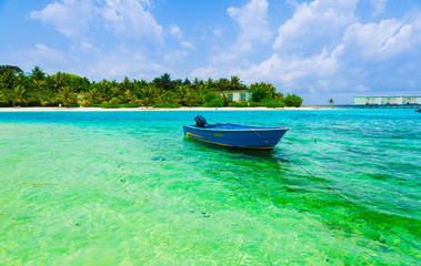 Naklejka na ściany i meble Boat stands on crystal clear water by the beach in the maldives
