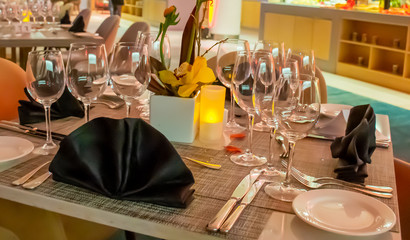 Romantic dinner table setup decoration with candle light in a restaurant. Selective focus.