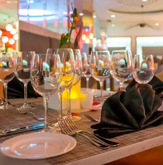 Romantic dinner table setup decoration with candle light in a restaurant. Selective focus.