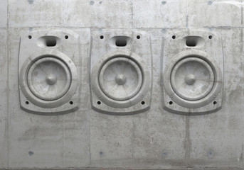 Cement sculpture in the shape of a sound speaker on a concrete facade wall. 3D wall panel of audio system. Creative conceptual modern art. Music wall. 3D rendering.