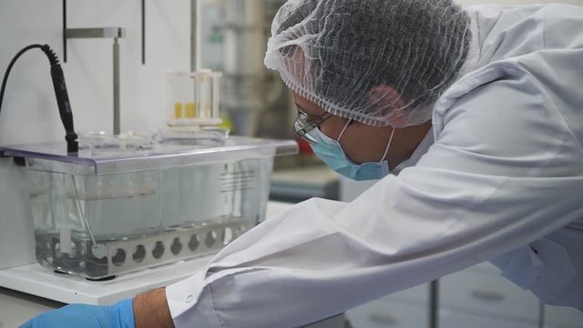 Tablets being tested in the dissolution apparatus at the pharmaceutical lab Spbd. doctor scientist watching the process. quality control concept. development of new medicine
