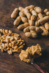 Peanuts in many ways: peeled, shelled and in peanut butter on a rustic wooden table