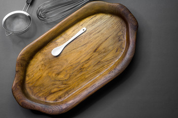 The wooden tray contains white ceramic spoon