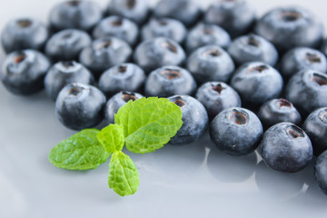 Obraz na płótnie Canvas Blueberries and a leaf of fresh mint. Vitamins and antioxidants. Macro view.