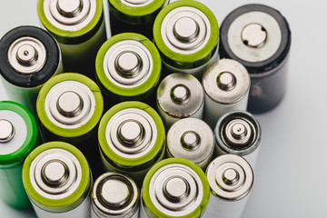 many new and used alkaline the positive ends of battery cells. type AA on a light background.