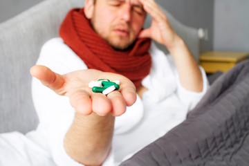 Pills in the hands of a patient close-up. Photo of pills in a male hand. A handful of pills. A lot of vitamins in capsules on the palm.