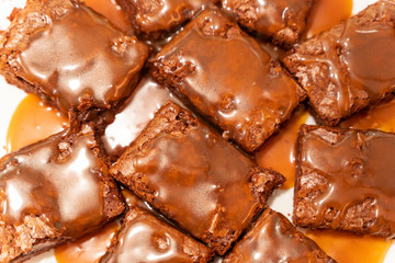 Top view on pieces of brownie poured with salted caramel sauce