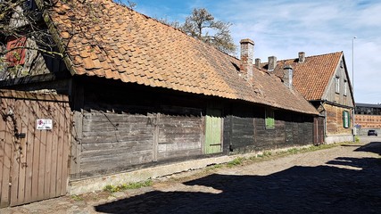 Fototapeta na wymiar On the streets of the Latvian city of Liepaja there are old wooden houses. April 2020