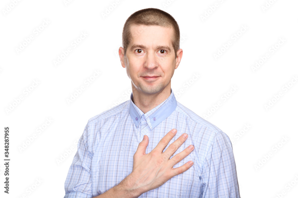 Wall mural Joyful man in love in a classic blue shirt; Put his hand on heart. look into the camera. Isolated