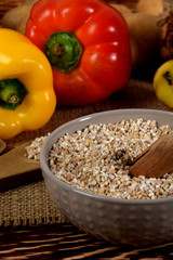 yellow and red raw peppers, dried plums next to potatoes and barley groats and dried mushrooms