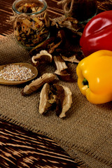 yellow and red raw peppers, dried plums next to potatoes and barley groats and dried mushrooms