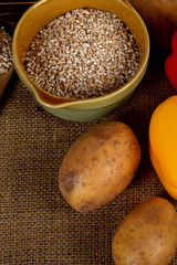 raw yellow pepper, dried plums next to potatoes and barley groats