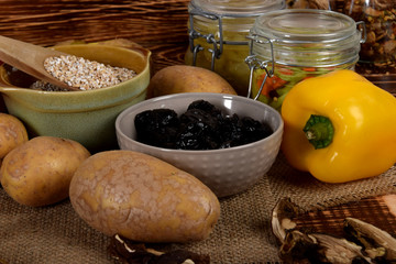 raw yellow pepper, dried plums next to potatoes and barley groats