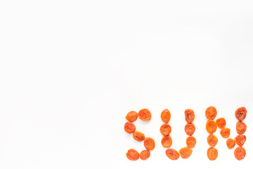 the word sun from dried apricots on a white background