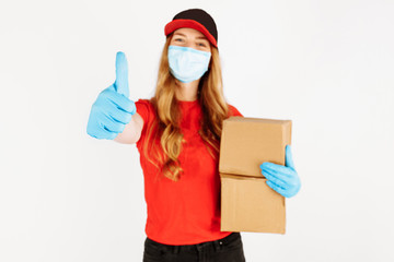 Fototapeta na wymiar The courier holds cardboard boxes in medical rubber gloves and a mask, on a white background. Online stores Quarantine, coronavirus