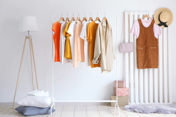 fashionable clothes on a rack in the interior of a bright room
