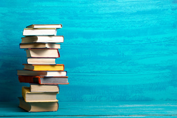 Composition with vintage old hardback books, diary, fanned pages on wooden deck table and abstract background. Books stacking. Back to school. Copy Space. Education background.