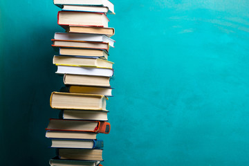 Composition with vintage old hardback books, diary, fanned pages on wooden deck table and abstract background. Books stacking. Back to school. Copy Space. Education background.