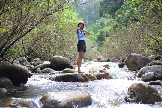 Woman standing on a rock at Trok Nong Waterfall in Chanthaburi, Thailand