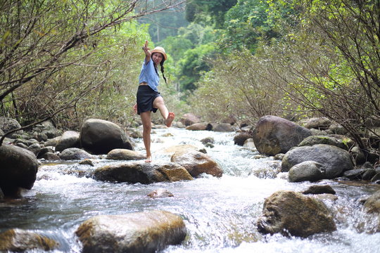 Woman standing on a rock at Trok Nong Waterfall in Chanthaburi, Thailand