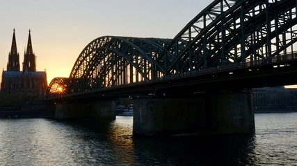 Obraz premium Kölner Dom und Hohenzollernbrücke im Sonnenuntergang am Abend