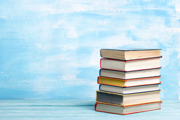 Composition with vintage old hardback books, diary, fanned pages on wooden deck table and abstract background. Books stacking. Back to school. Copy Space. Education background.