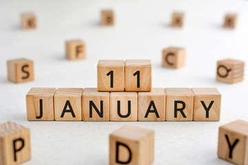 January 11 - from wooden blocks with letters, important date concept, white background random letters around