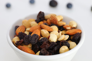 Nuts and berries are scattered on the table. nuts are in the plate.