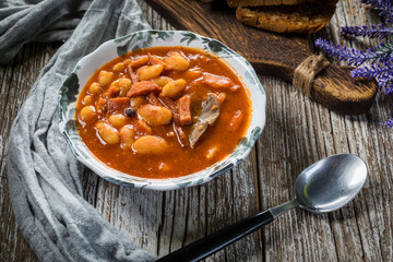 Beans with tomato sauce, bacon and sausage.