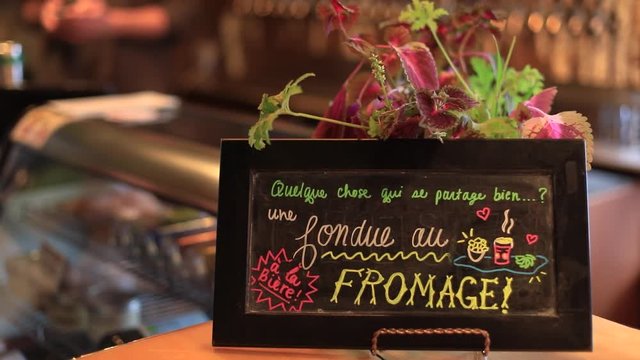 Quelque chose qui se partage bien - une fondue all fromage written in french on blackboard denoting something that is shared well - a cheese fondue