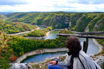 Young man looks at meanders in Nature park Uvac, Serbia.