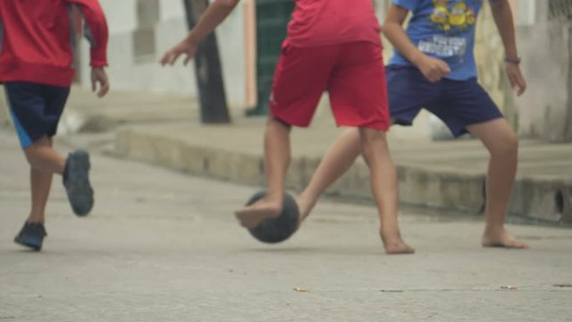 Children Training Playing Football Barefoot In Ghetto, Cuba. Footbal game around the world concept. The Republic of Cuba, urban scene. Football and soccer in Cuba
