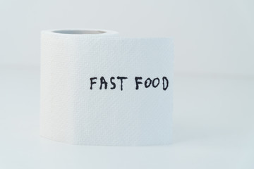 Toilet paper with text fast food in wc. Concept of personal hygiene. Fast food Concept