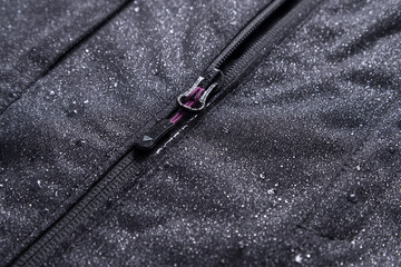 Black moisture resistant fabric jacket surface with water drops