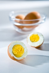Cut in half and whole boiled eggs on the white background