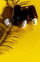 Vitamin D E A C B bottle yellow shadow light tropical leaves white background sun 3 omega