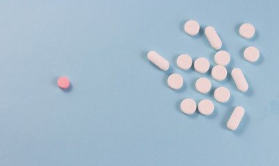 White pills on a blue background are located in a group and one red pill. Copyspace for text.