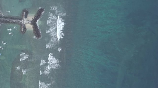 Blauer Ozean mit Wellen und kleinen Boten aus der Luft